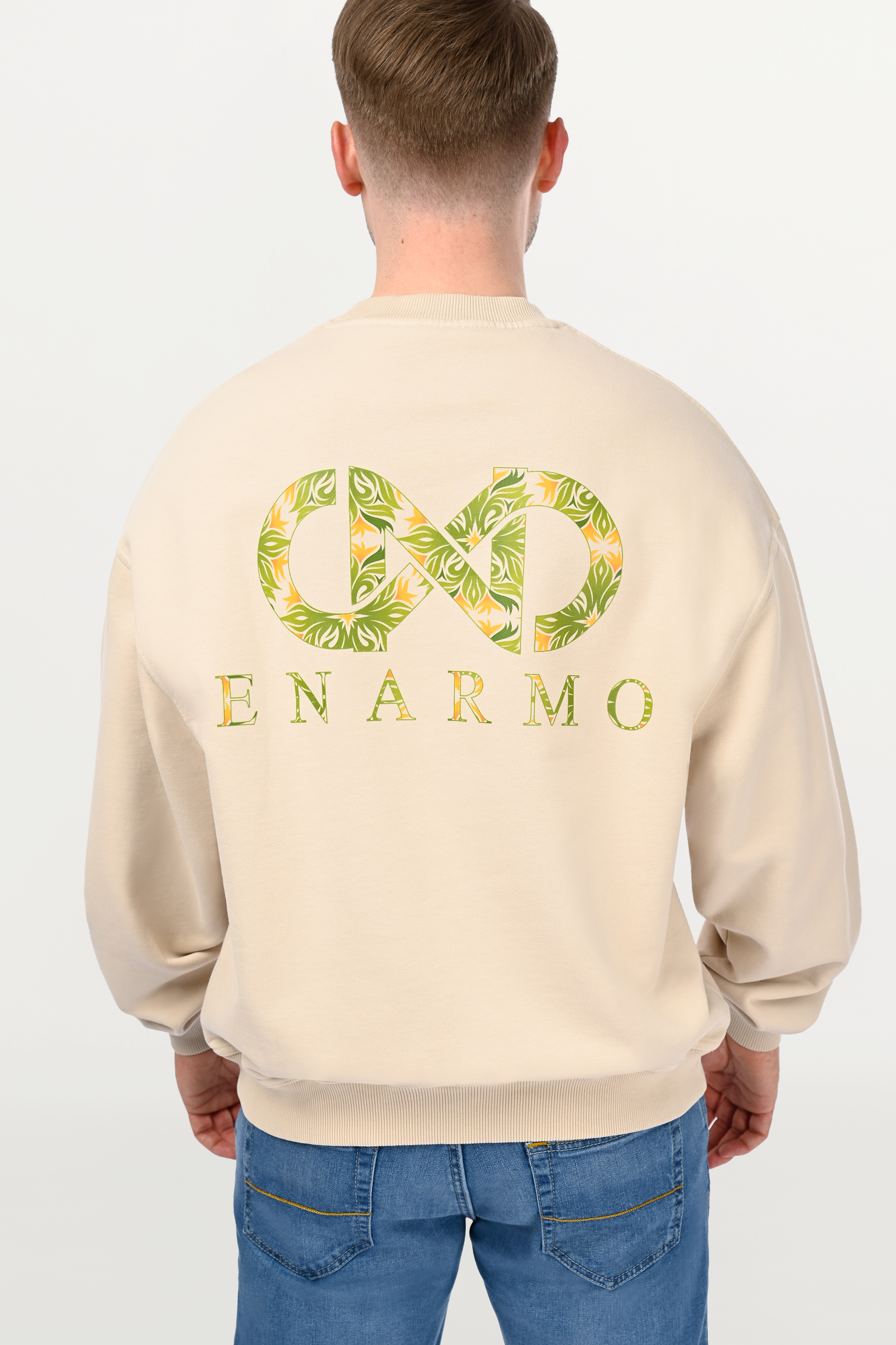 Close-up of bold yellow and green back logo print on beige oversized cotton sweatshirt, statement graphic detail with high-contrast finish.