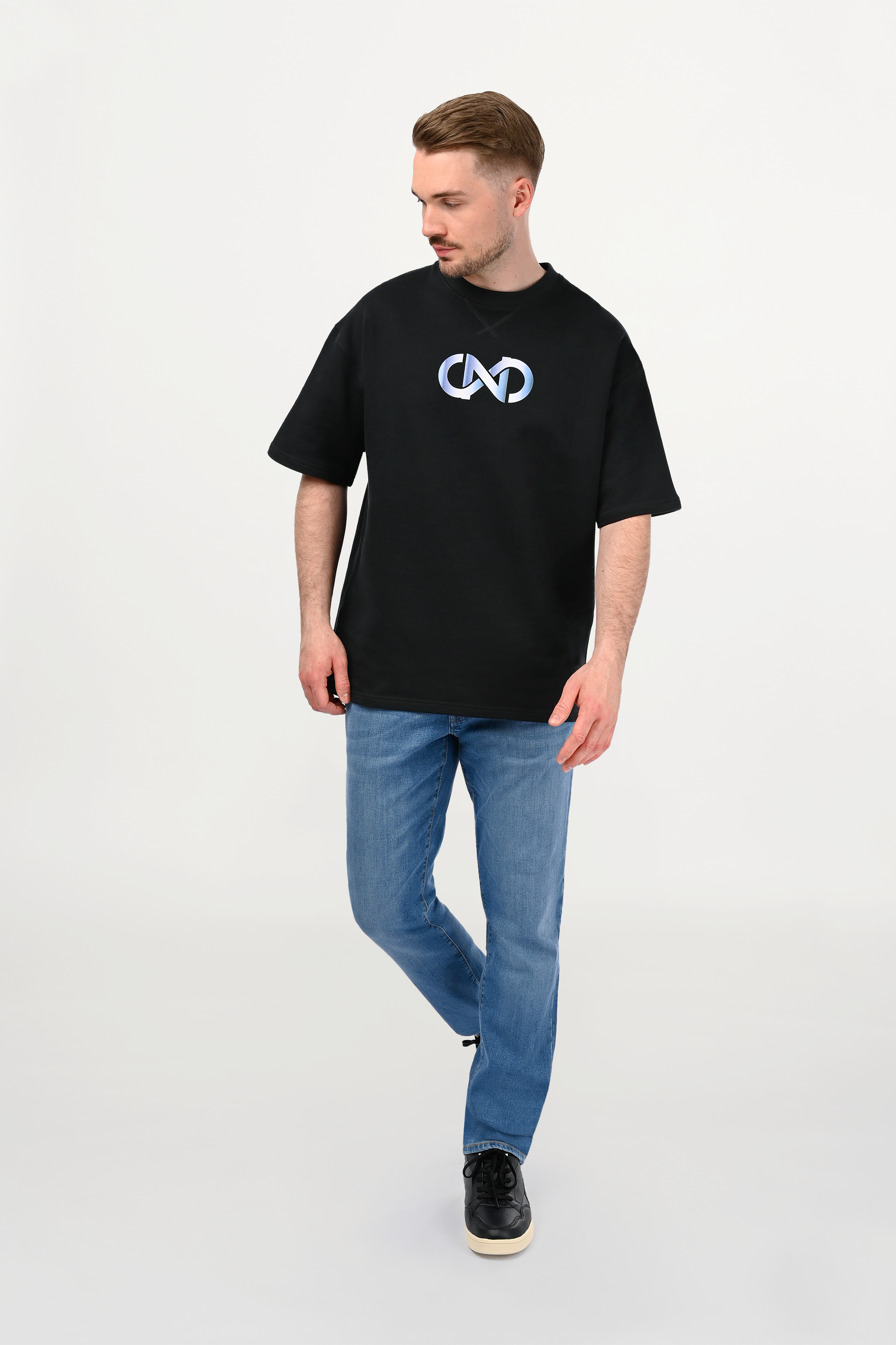 Male model wearing black oversized cotton T-shirt with white-to-sky-blue gradient chest motif, relaxed luxury streetwear fit, handmade ENARMO design front view