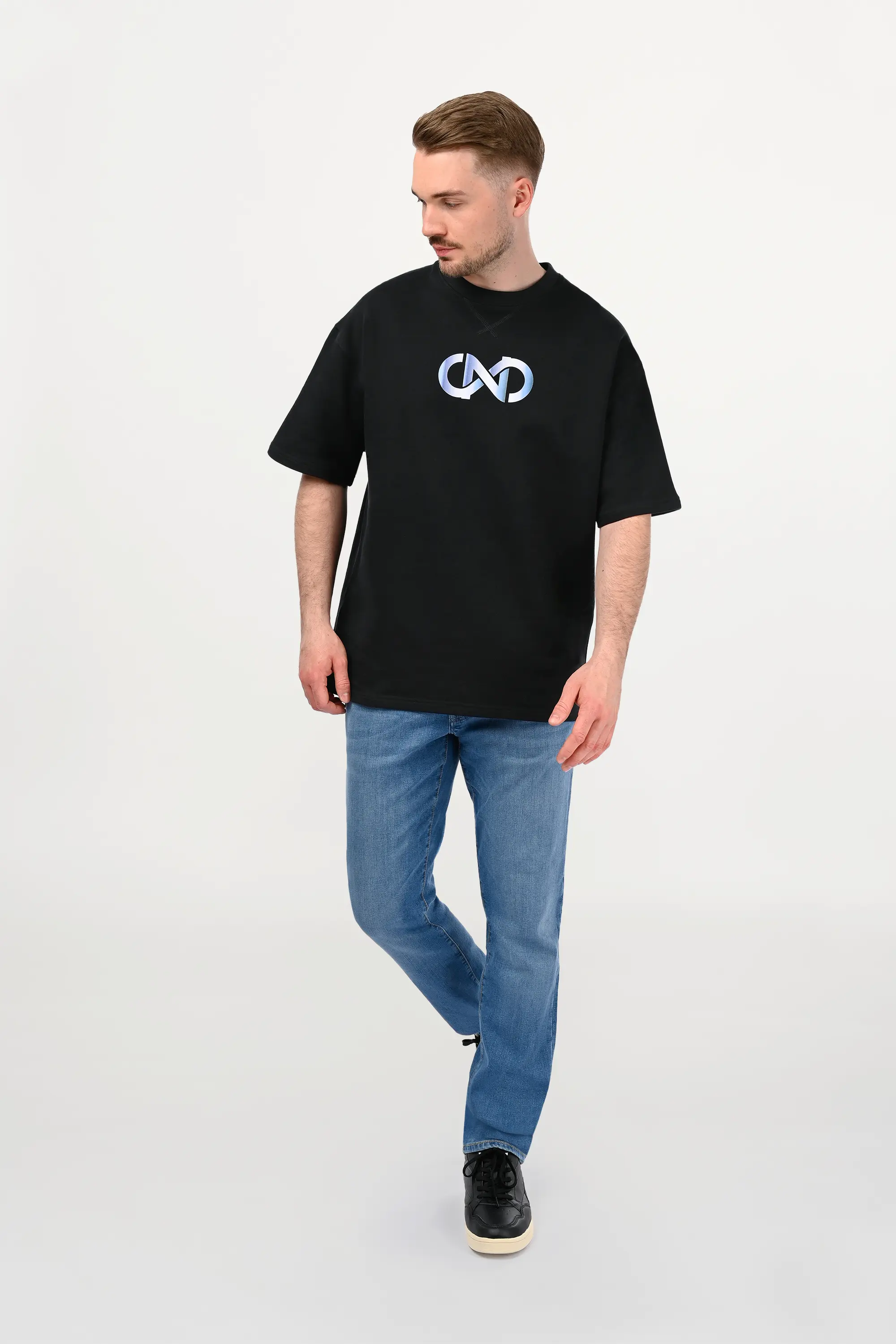 Male model wearing black oversized cotton T-shirt with white-to-sky-blue gradient chest motif, relaxed luxury streetwear fit, handmade ENARMO design front view