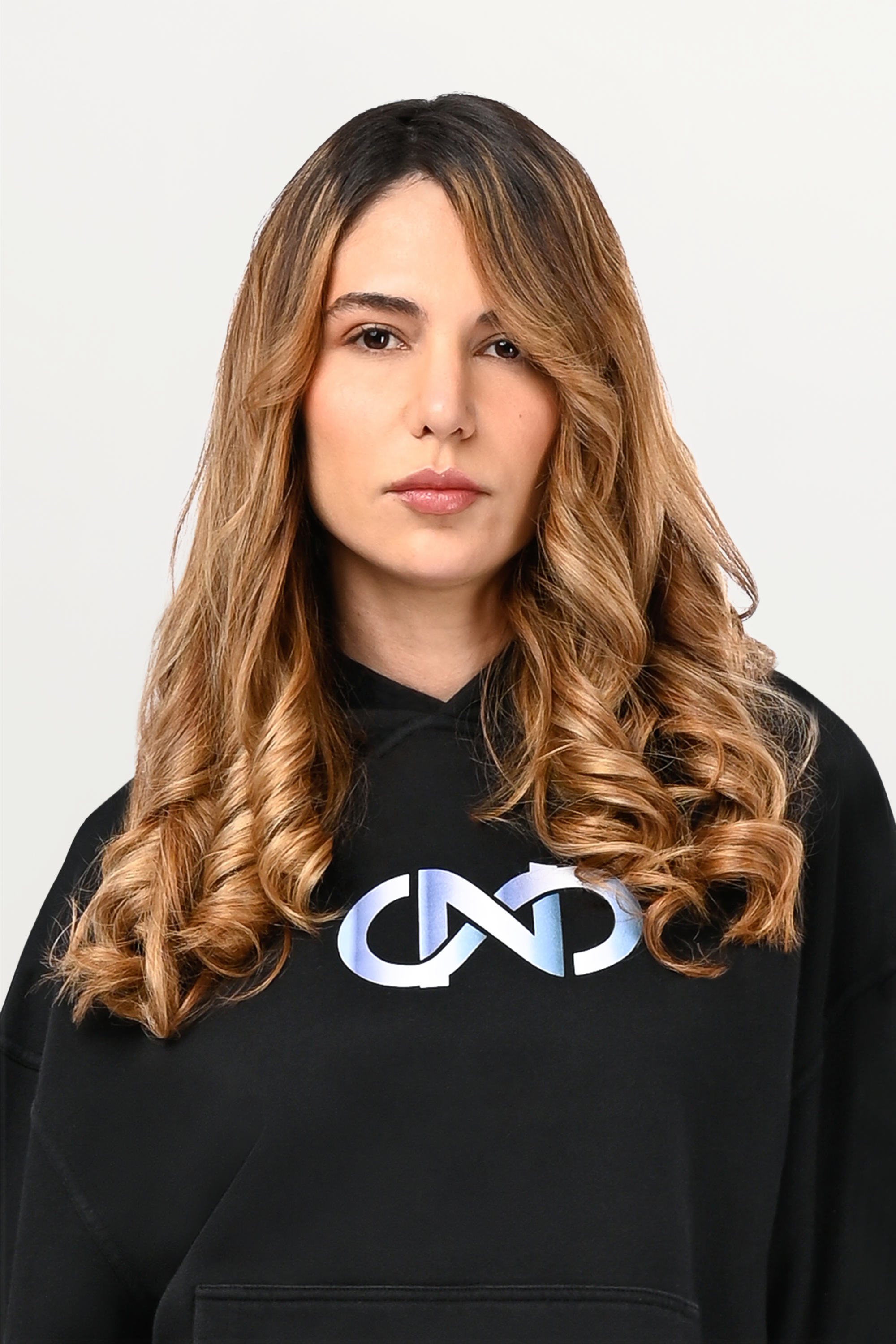Close-up of gradient logo design on black oversized hoodie, white-to-sky-blue print detail on premium cotton fabric.