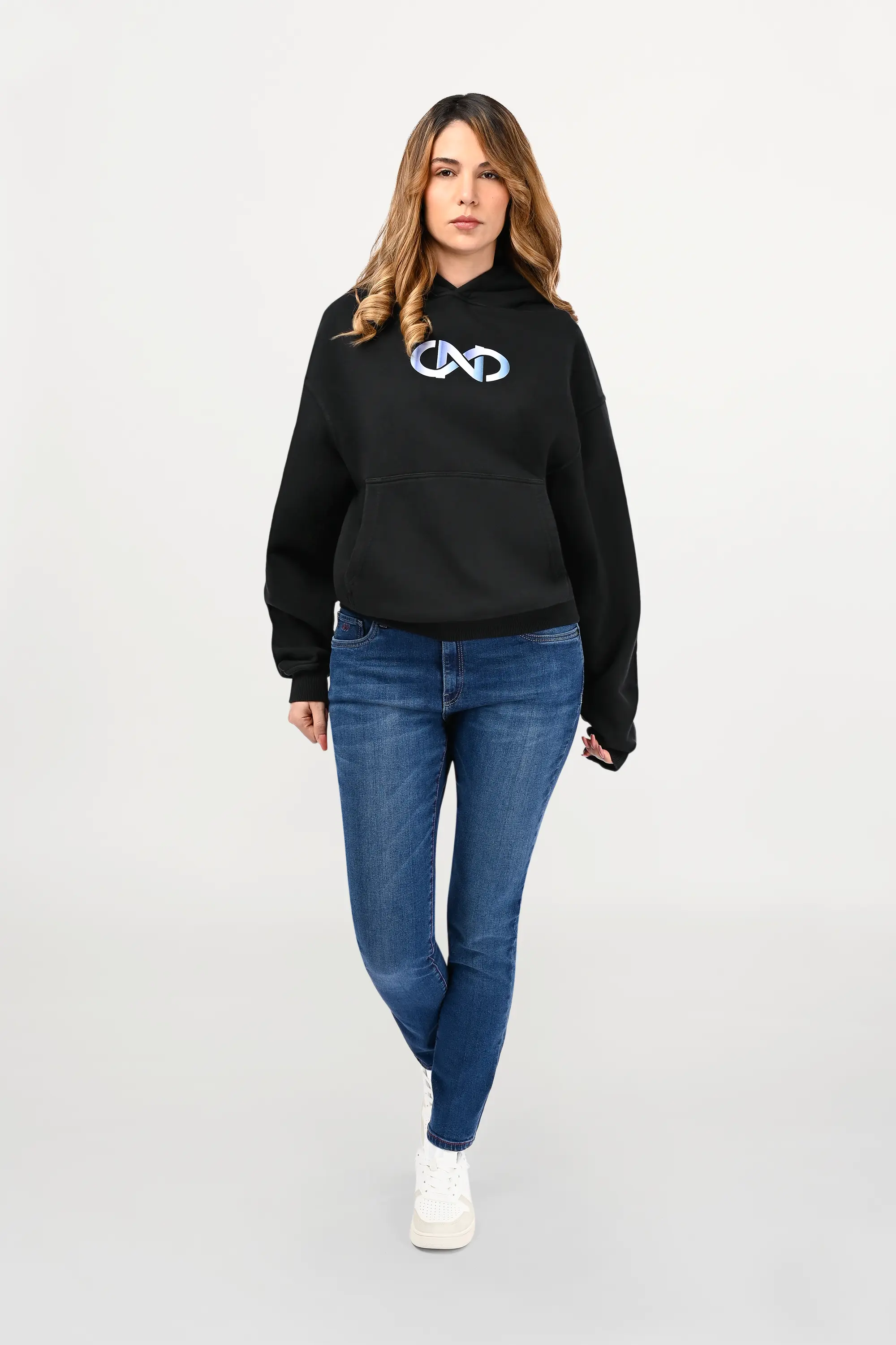 Female model wearing black oversized cotton hoodie with sky gradient chest motif fading from white to light blue, relaxed unisex silhouette.