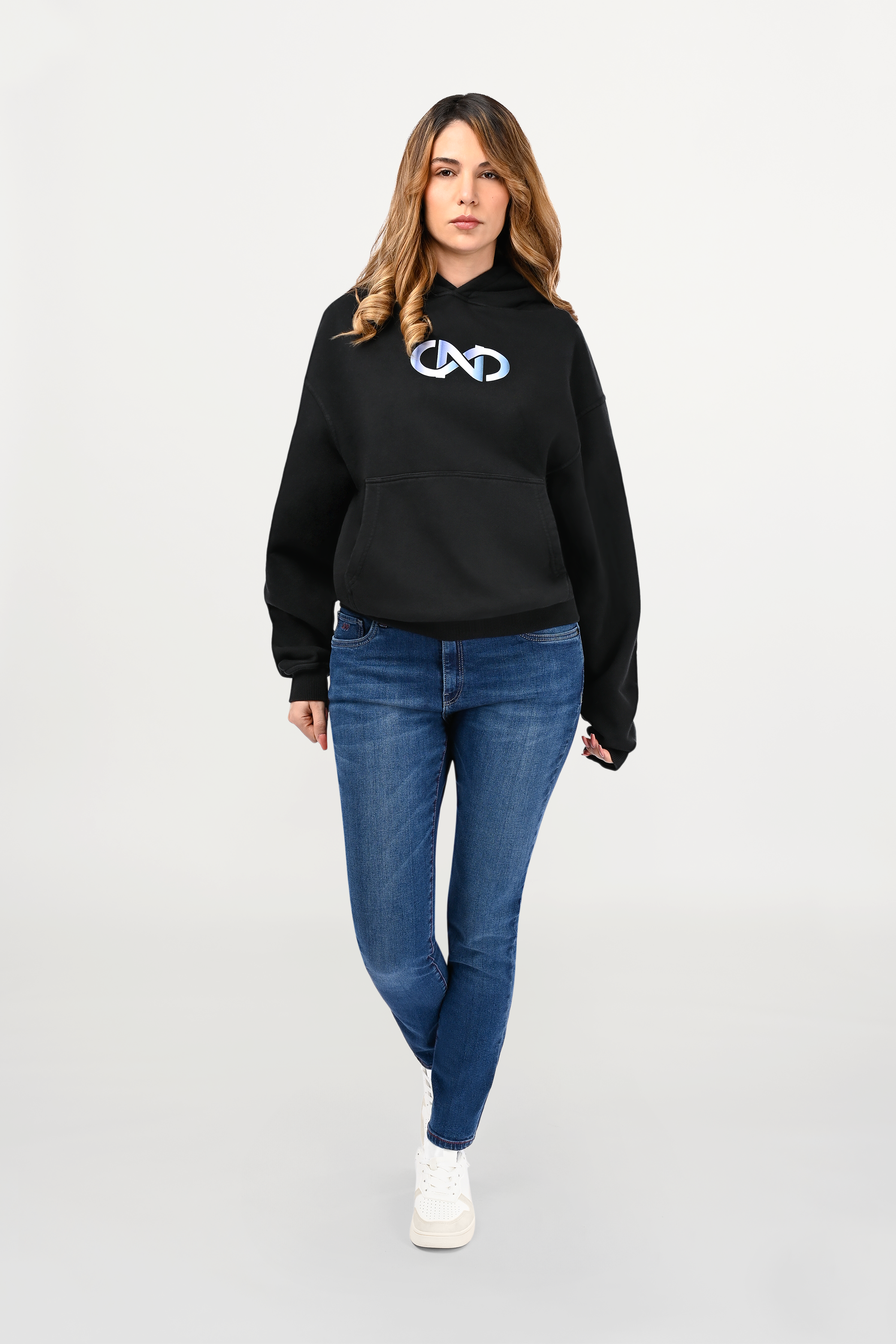 Female model wearing black oversized cotton hoodie with sky gradient chest motif fading from white to light blue, relaxed unisex silhouette.