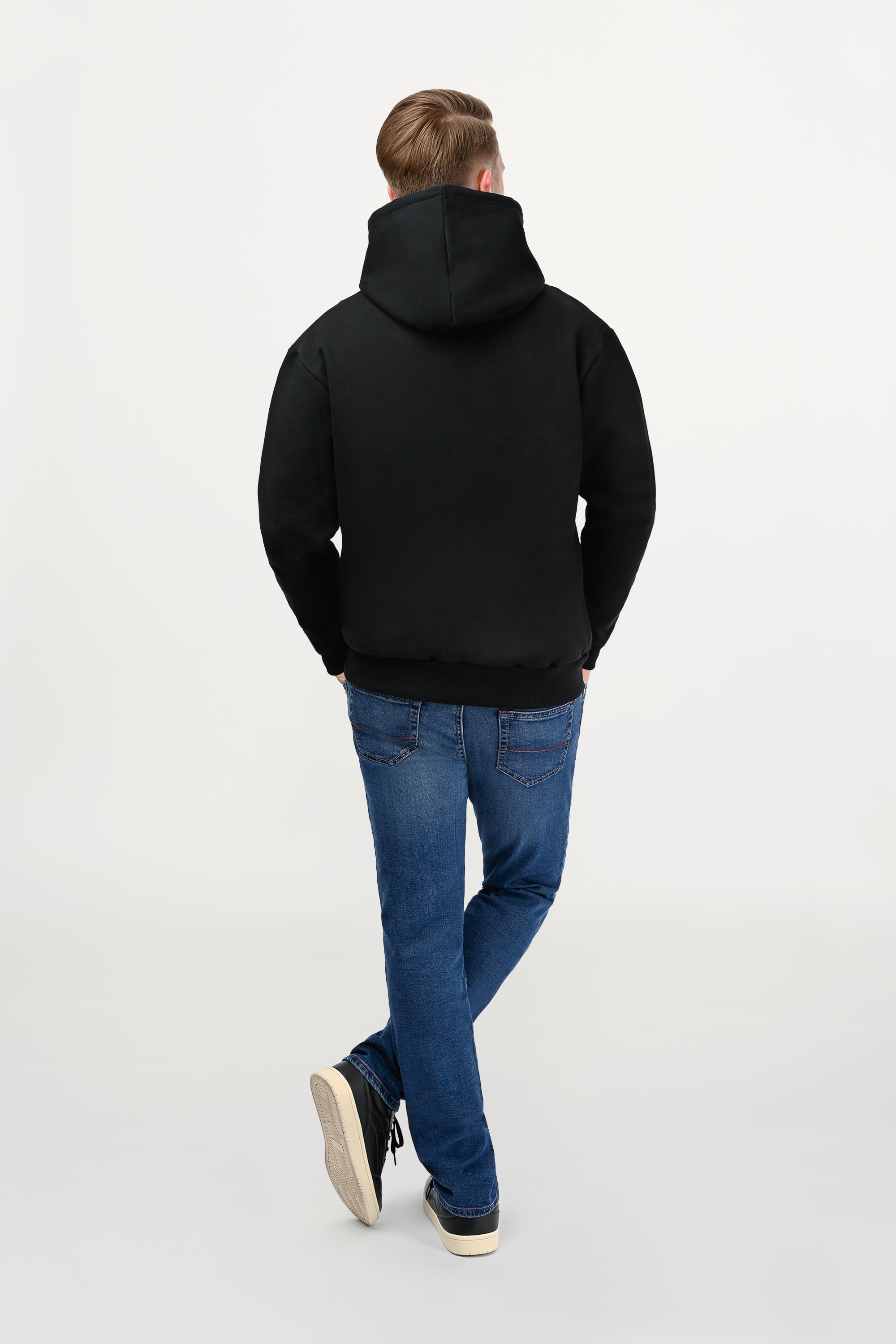 Back view of male model in black designer hoodie, clean rear design with structured regular fit and elevated minimalist styling.
