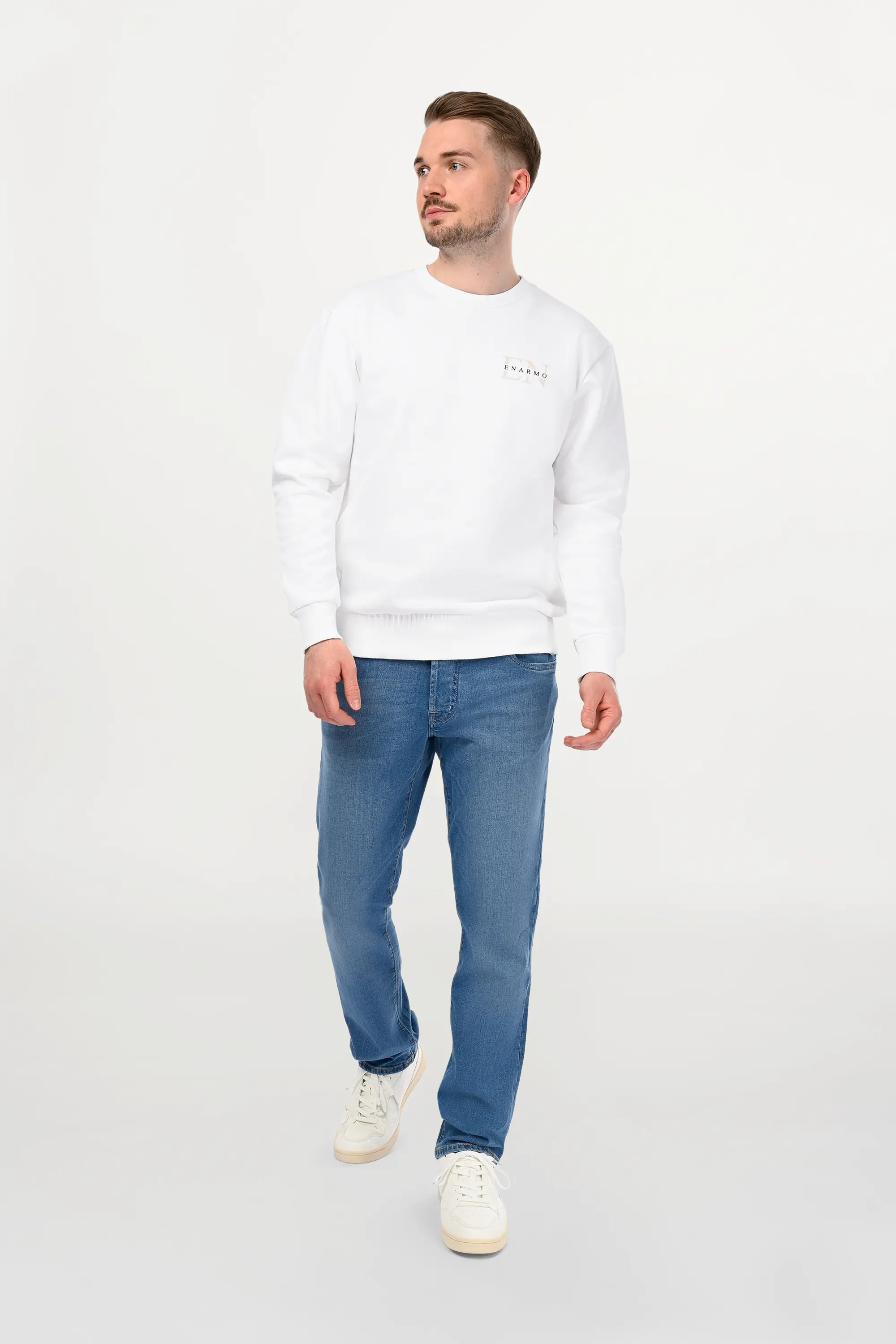 Male model wearing light blue regular fit denim jeans with clean wash and classic five-pocket construction, modern designer denim front view.