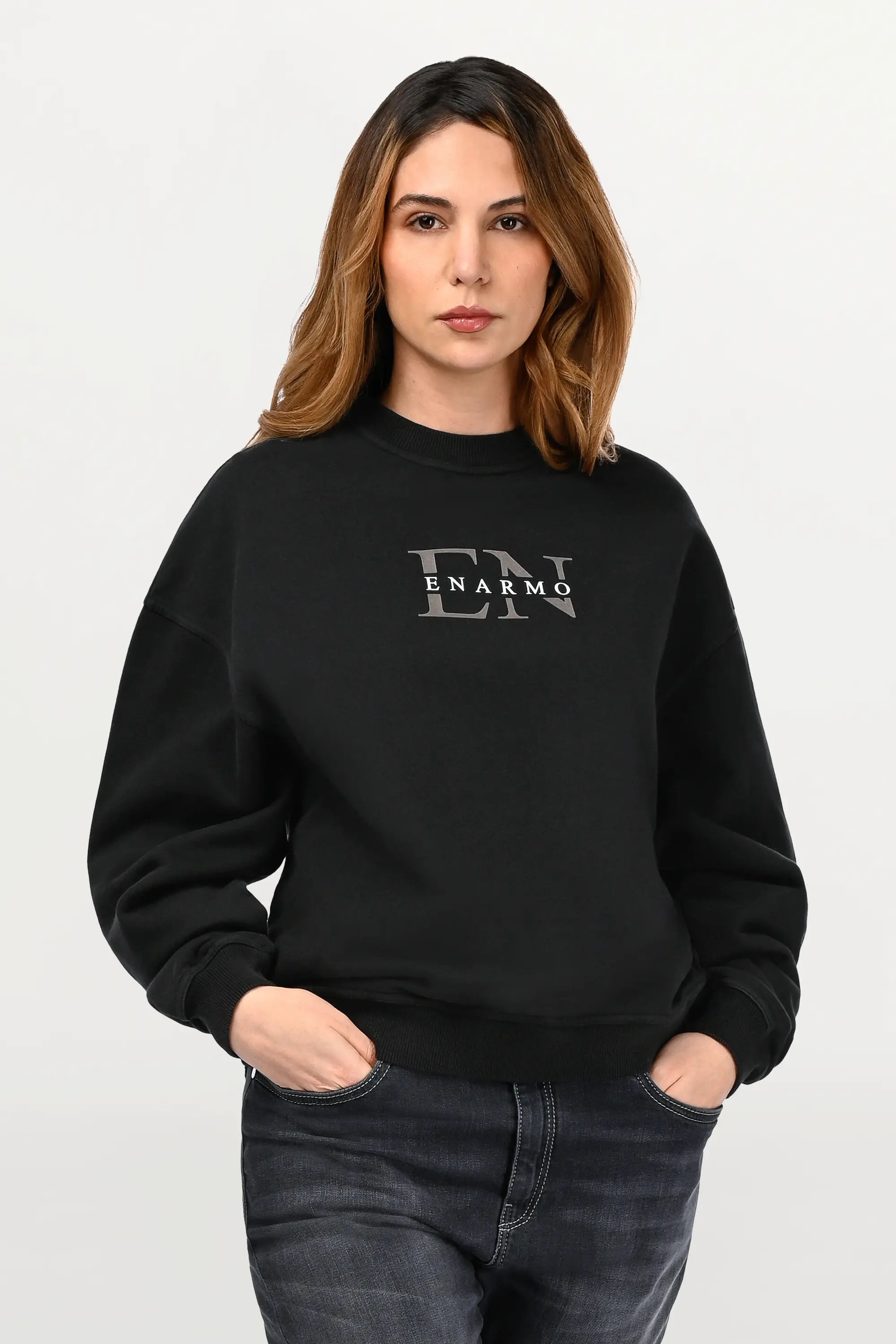 Close-up of black oversized crewneck on female model featuring EN monogram chest print, textured French Terry fabric and bold contrast detailing.
