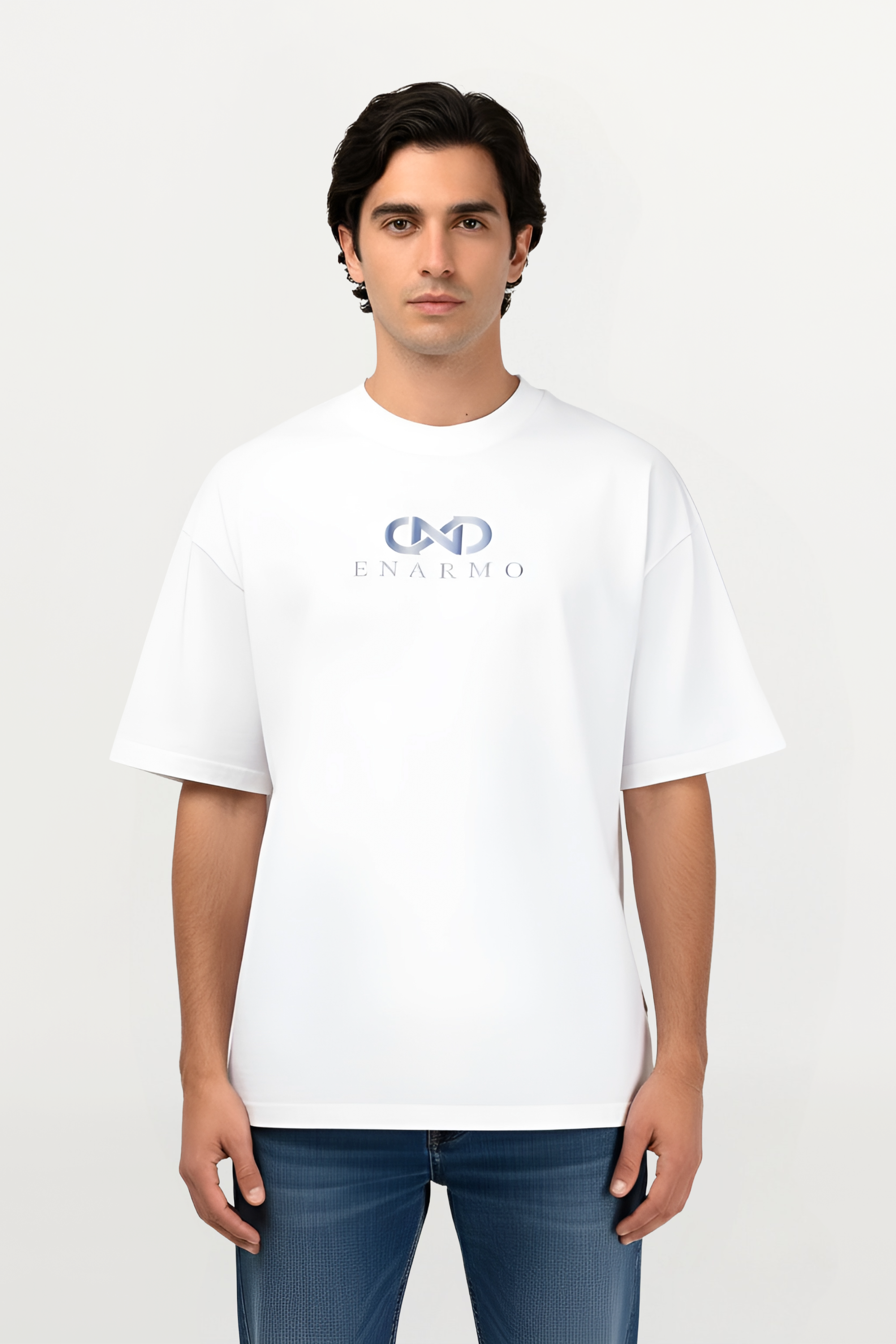 Male model wearing white oversized cotton T-shirt with sky-gradient chest logo, detailed close-up of premium cotton and subtle ENARMO branding, luxurious streetwear fit.