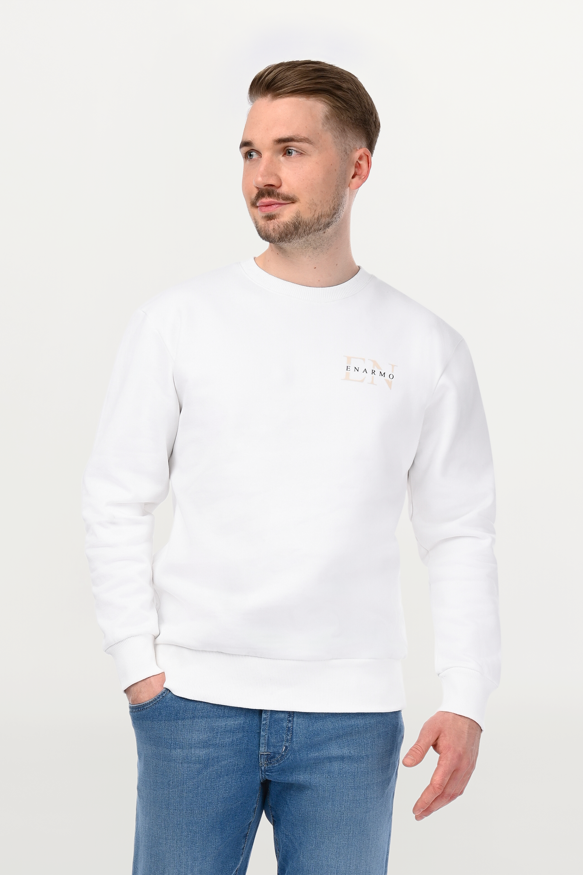 Close-up of beige EN monogram and black ENARMO lettering on white cotton sweatshirt, detailed chest placement.