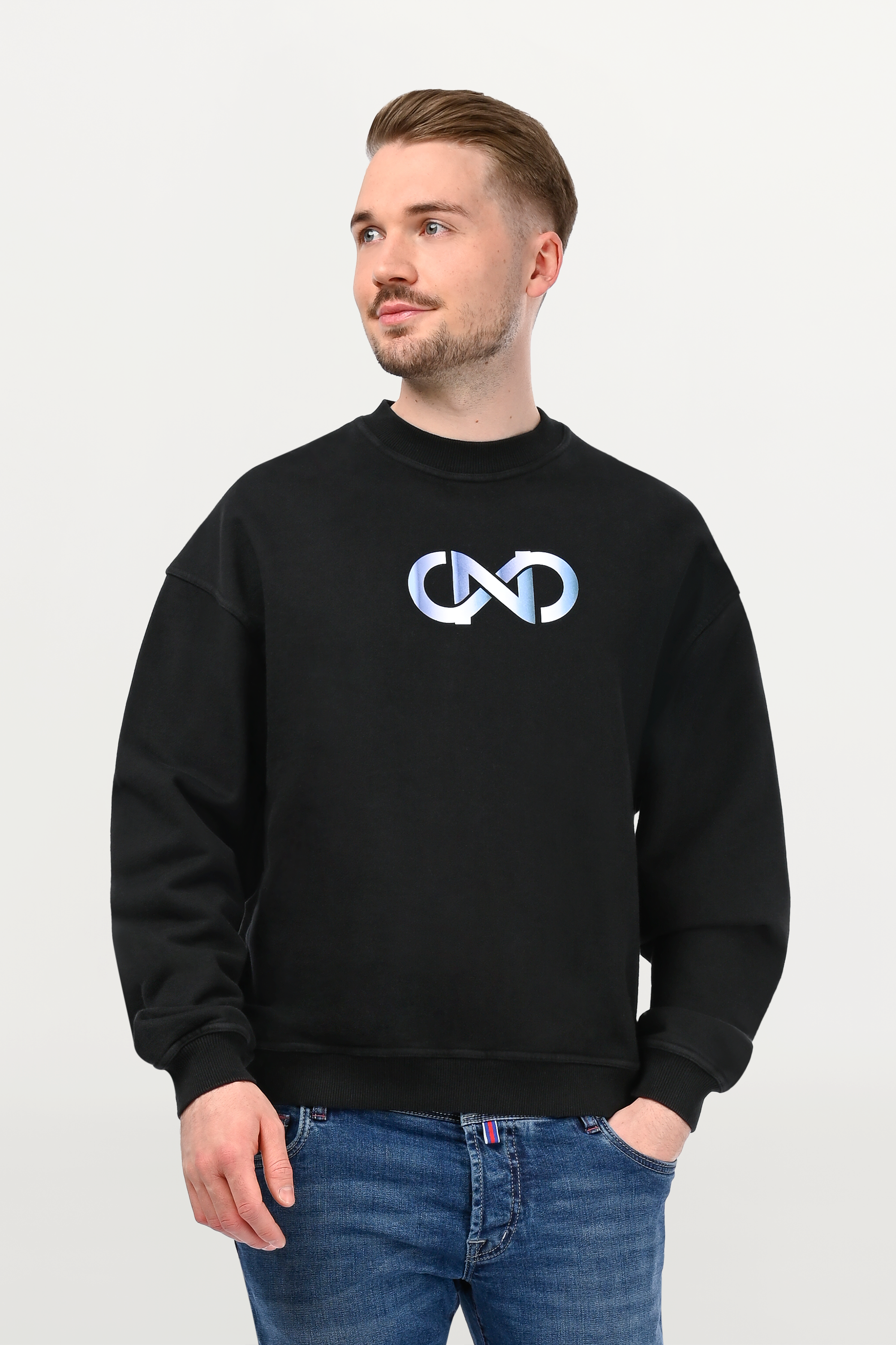 Close-up of black oversized crewneck featuring sky gradient logo motif on chest, smooth cotton surface and contemporary graphic detail.