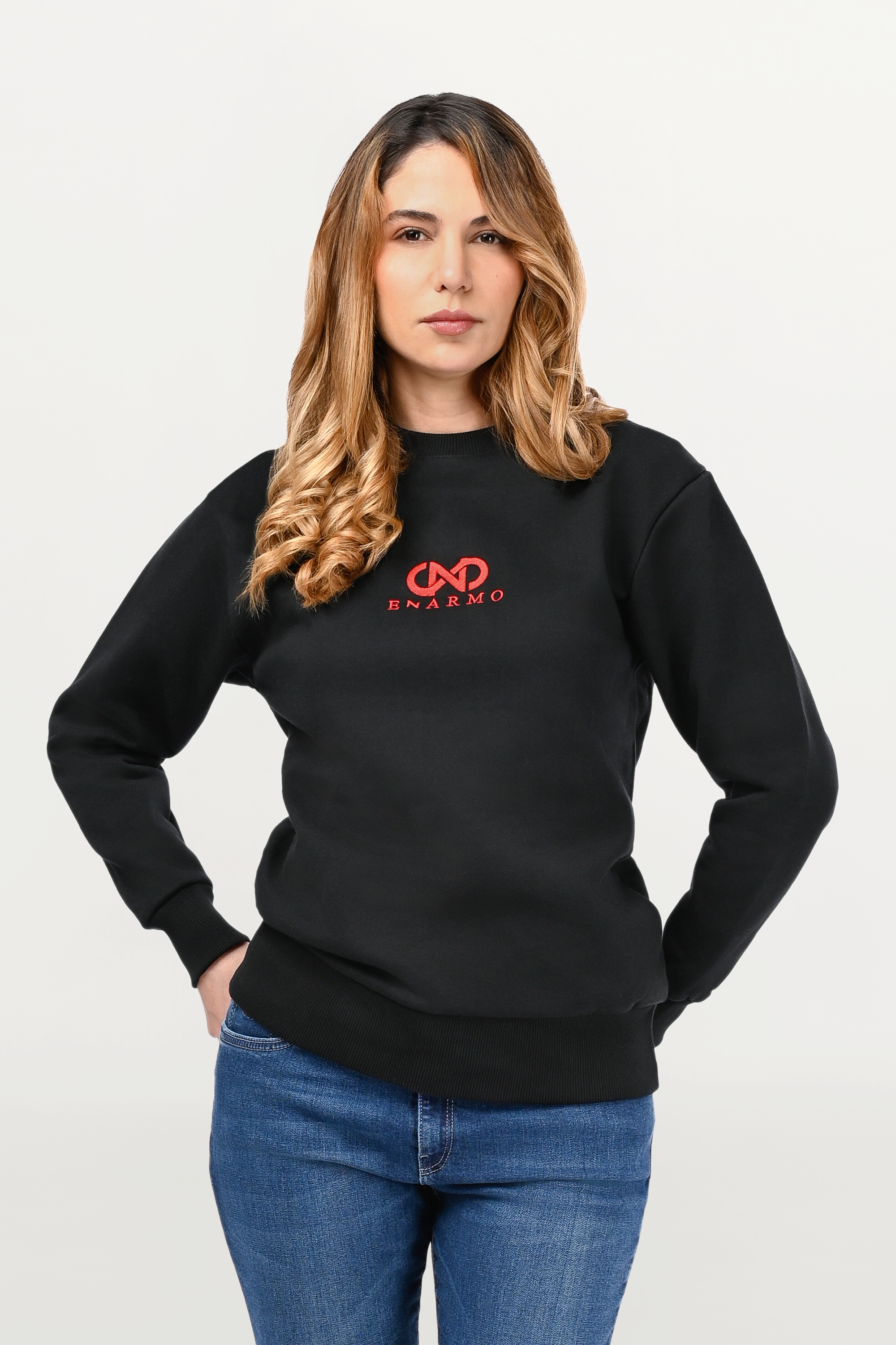 Close-up of red embroidered ENARMO logo on black cotton sweatshirt, detailed stitching and soft fleece-lined structure.