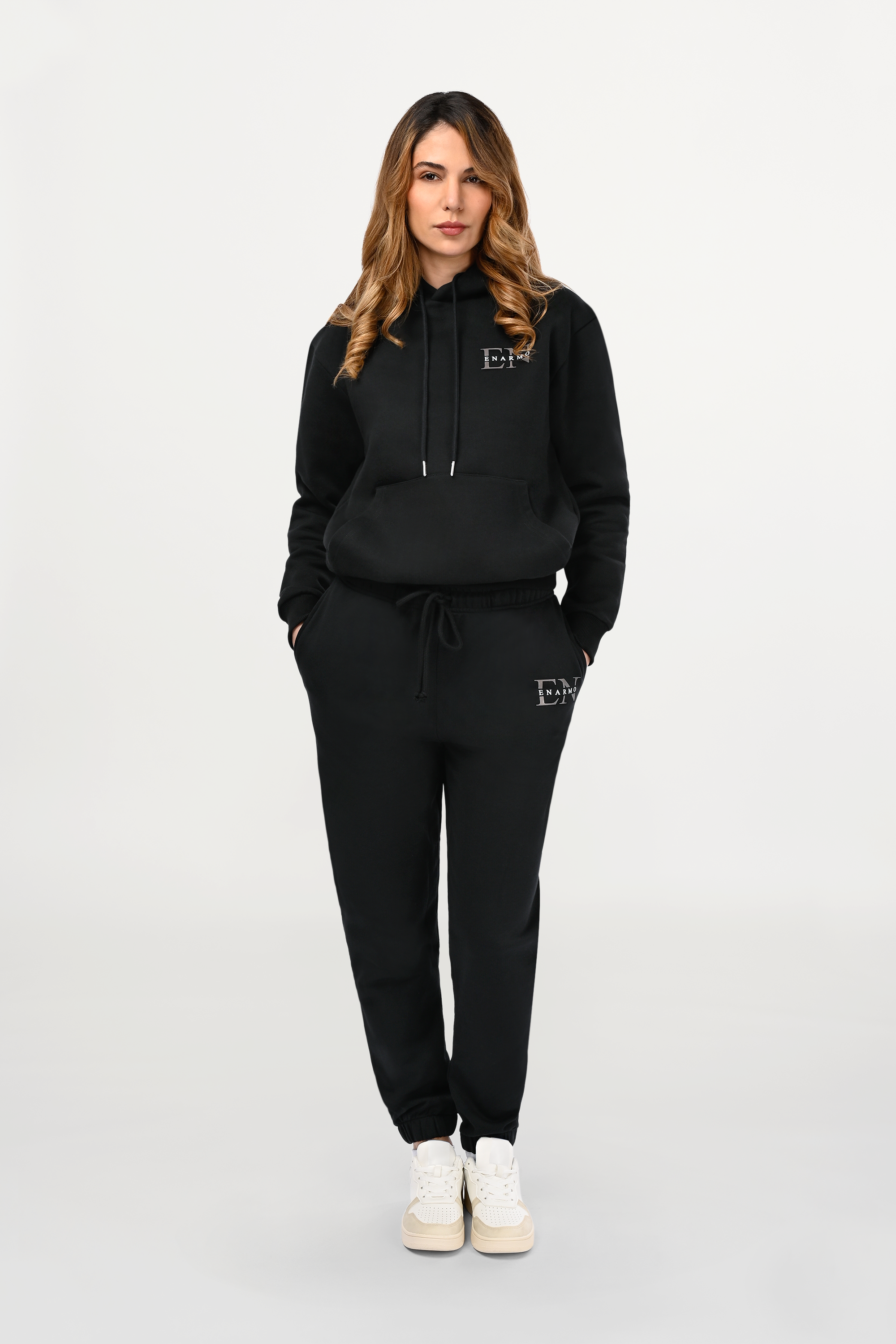 Female model styled in black designer hoodie with printed EN Monogram, sharp regular cut and refined minimalist expression.