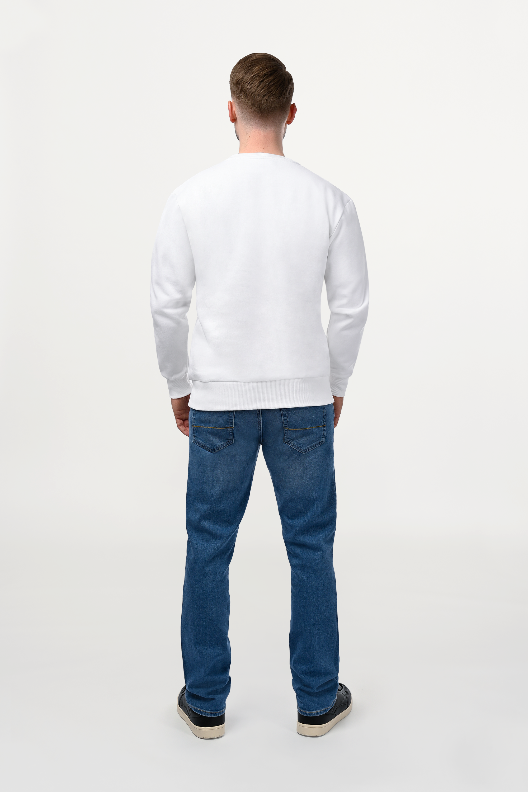 Back view of male model in white ENARMO sweatshirt, clean design, structured silhouette, premium cotton finish.